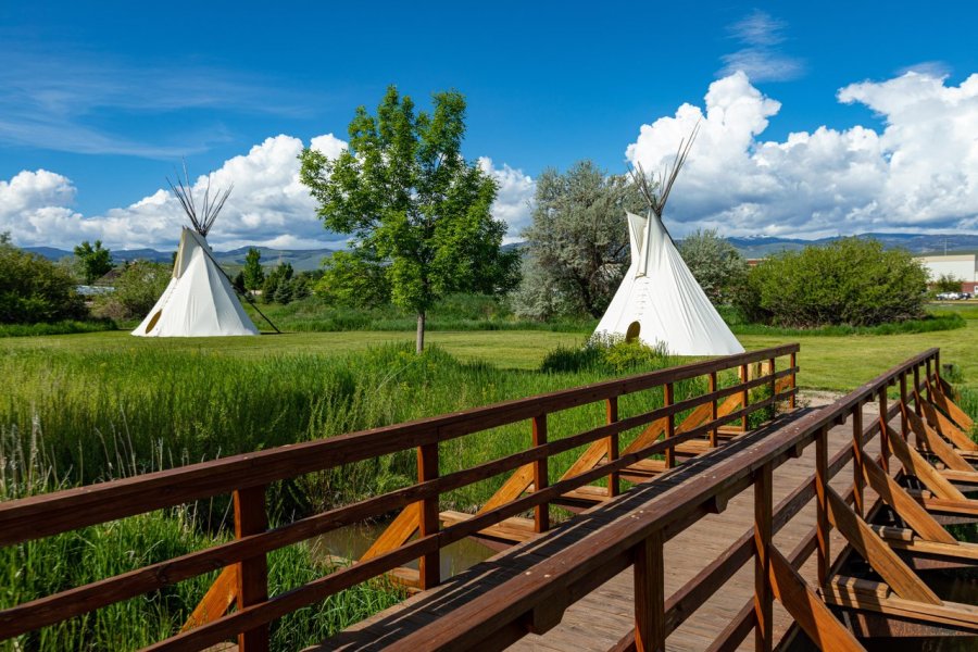 A group dressed in historic attire stands near wagon wheels at Fort Laramie National Historic Site.
