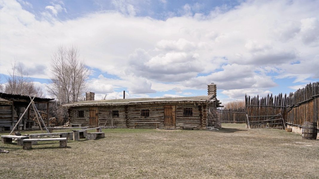 Tracing the Past: 6 Historic Trails In Wyoming 3 Clouds hang over the log cabin and wooden outbuildings at Fort Bridger State Historic Site.
