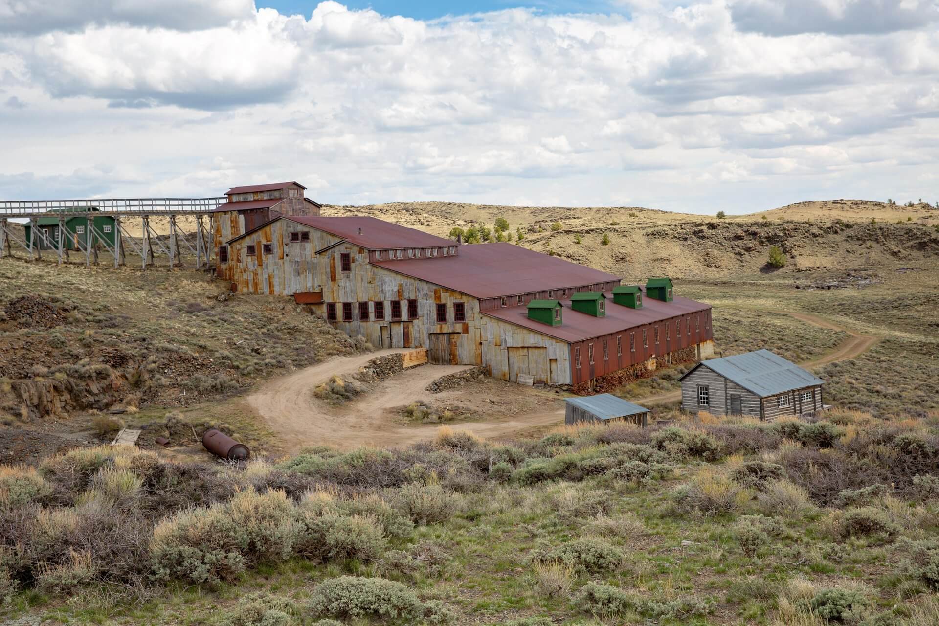 Wyoming’s Heritage: Rooted in the Modern American Spirit 2 Historic structures from Carissa Mine at South Pass City, surrounded by a landscape of desert brush and hills.